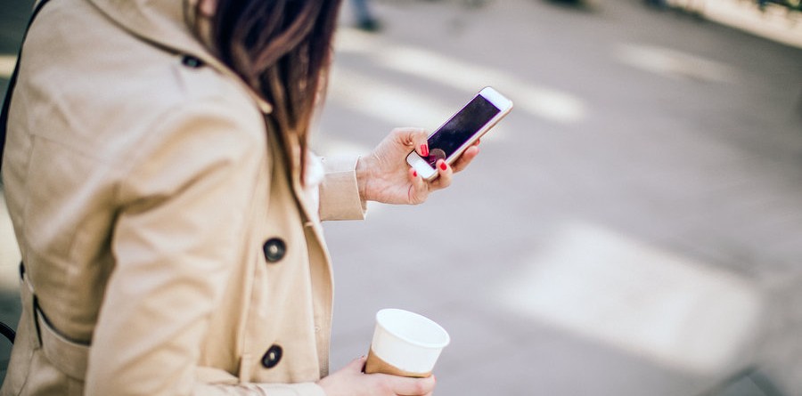 girl texting with coffee tänav